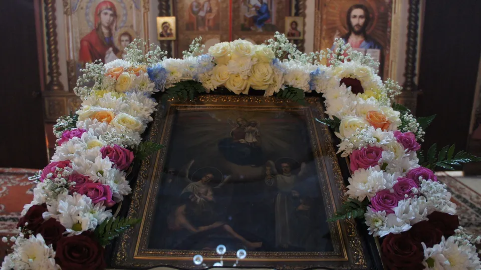 Икона Божией Матери «Всех скорбящих Радость» в золочёном окладе, украшенная цветами